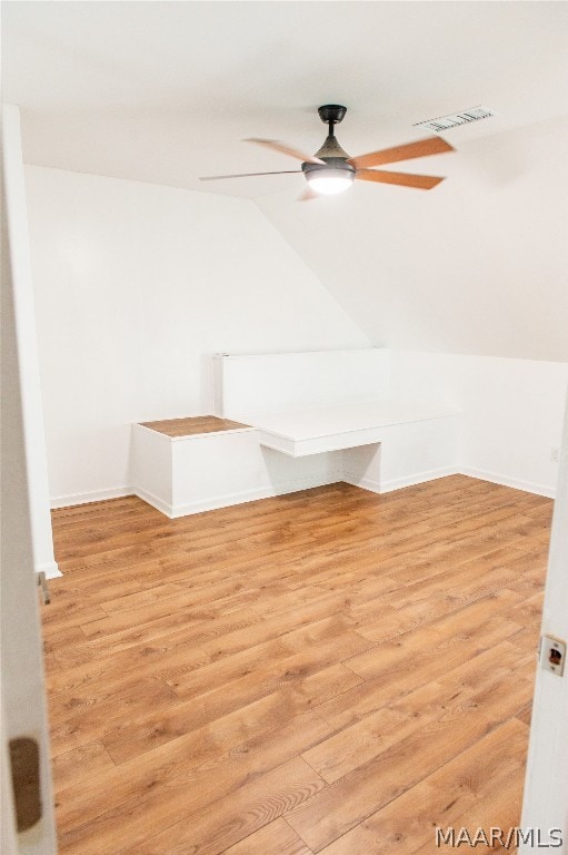 interior space featuring ceiling fan, light hardwood / wood-style floors, and vaulted ceiling