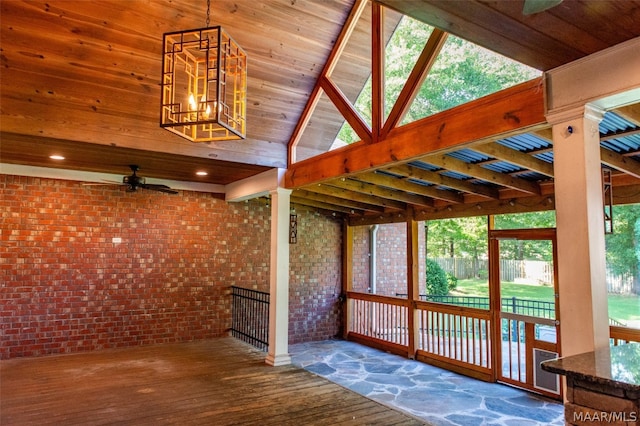 unfurnished sunroom with a wealth of natural light, ceiling fan, and vaulted ceiling with beams