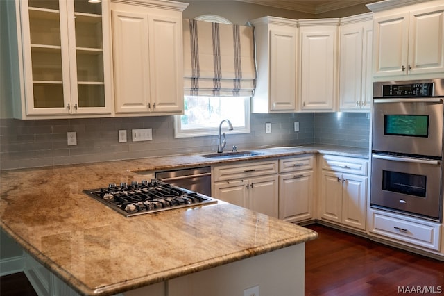 kitchen featuring white cabinets, stainless steel appliances, light stone counters, and sink