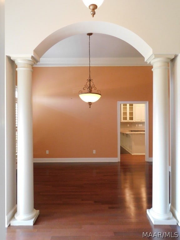 unfurnished dining area featuring dark hardwood / wood-style flooring and ornamental molding