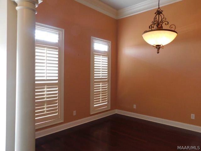 empty room with ornate columns, dark hardwood / wood-style flooring, and ornamental molding