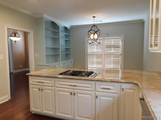 kitchen featuring light stone countertops, built in features, pendant lighting, stainless steel gas stovetop, and white cabinets