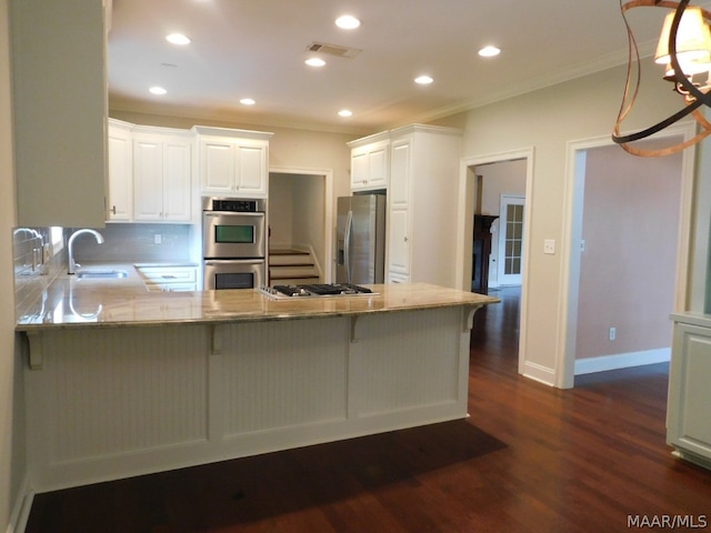 kitchen featuring sink, kitchen peninsula, ornamental molding, appliances with stainless steel finishes, and white cabinetry