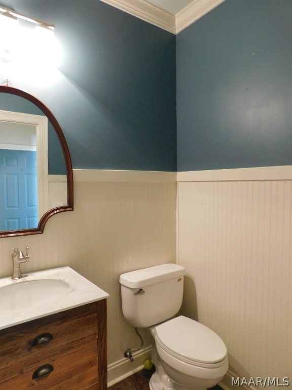 bathroom with vanity, toilet, and ornamental molding