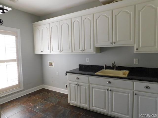 clothes washing area with hookup for a washing machine, a wealth of natural light, sink, and cabinets