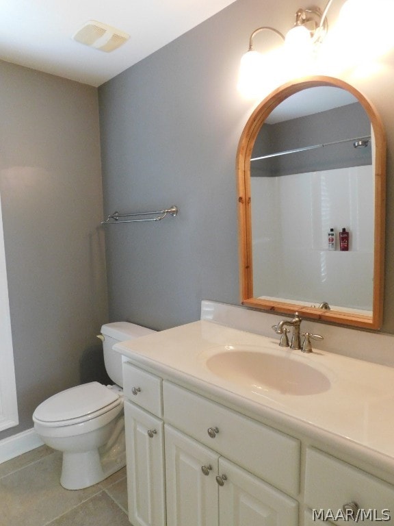 bathroom featuring tile patterned flooring, vanity, and toilet