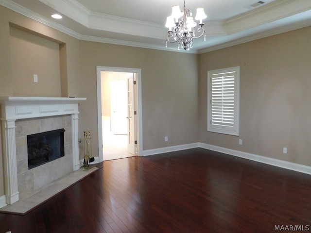 unfurnished living room featuring a notable chandelier, a raised ceiling, ornamental molding, and a tiled fireplace