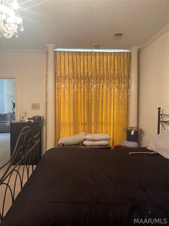 carpeted bedroom with crown molding, a chandelier, and a textured ceiling