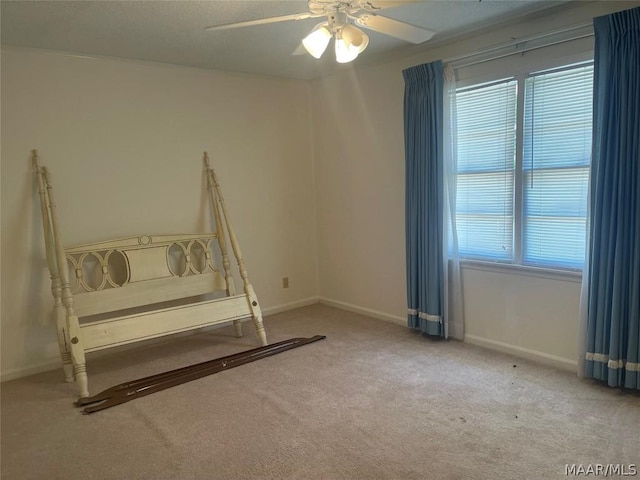 interior space with a textured ceiling, light colored carpet, ceiling fan, and ornamental molding