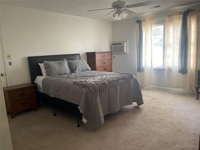 bedroom featuring a wall unit AC, ceiling fan, light colored carpet, and a textured ceiling