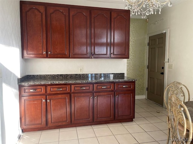 kitchen with light tile patterned floors, an inviting chandelier, and dark stone counters