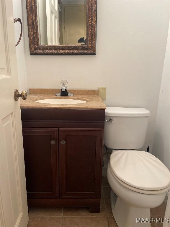 bathroom featuring tile patterned flooring, vanity, and toilet