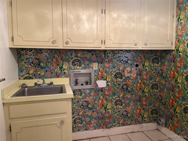 laundry area featuring light tile patterned flooring, cabinets, sink, and hookup for a washing machine