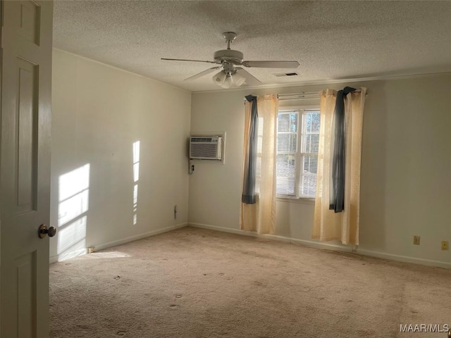 spare room featuring a textured ceiling, light colored carpet, a wall unit AC, and ceiling fan