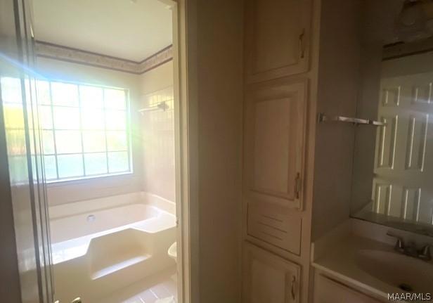 bathroom with vanity and a tub to relax in