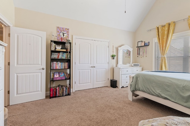 bedroom with a closet, light colored carpet, and vaulted ceiling