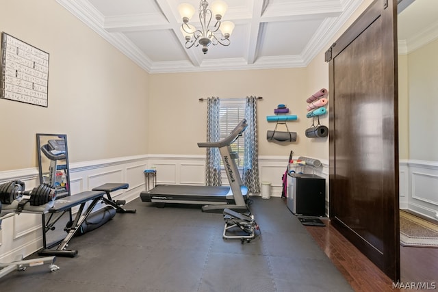 workout area featuring crown molding, coffered ceiling, and an inviting chandelier