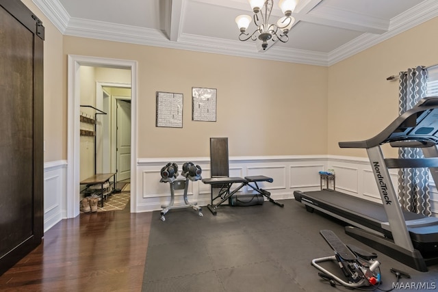 exercise area featuring coffered ceiling, crown molding, a barn door, a notable chandelier, and dark hardwood / wood-style flooring