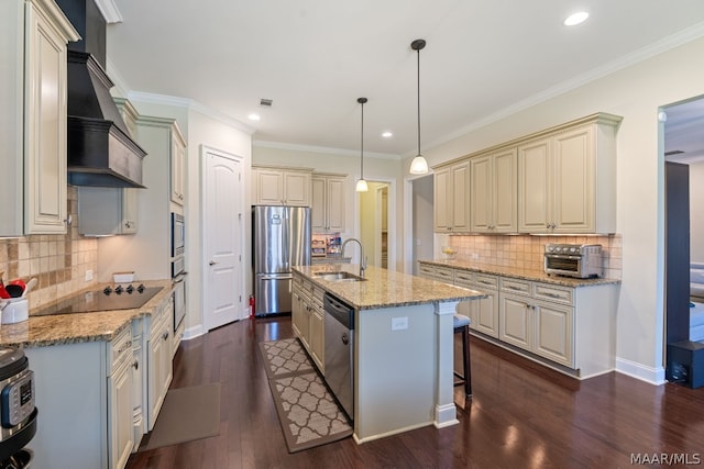 kitchen featuring stainless steel appliances, sink, decorative light fixtures, dark hardwood / wood-style floors, and an island with sink