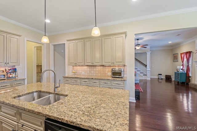 kitchen with pendant lighting, decorative backsplash, light stone counters, and sink