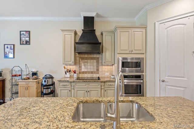 kitchen with sink, premium range hood, stainless steel appliances, and cream cabinets