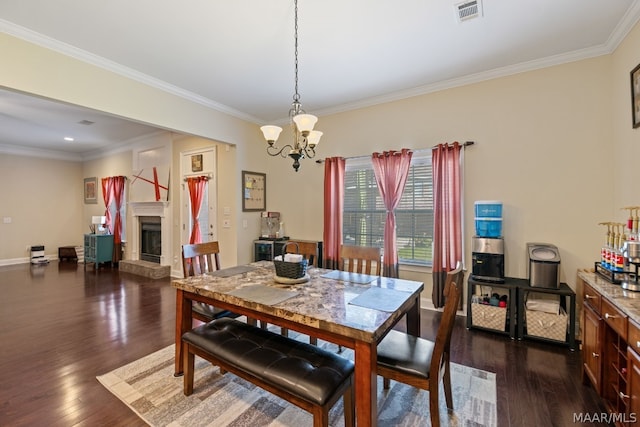 dining space featuring dark hardwood / wood-style floors, ornamental molding, and an inviting chandelier