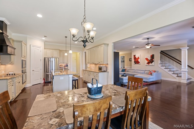 dining area with ceiling fan with notable chandelier, dark hardwood / wood-style flooring, and crown molding