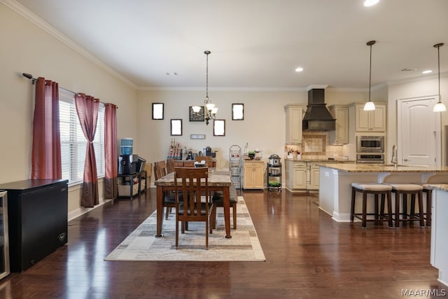 dining space with crown molding, dark hardwood / wood-style flooring, a chandelier, and sink