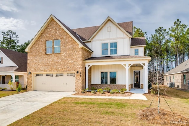 view of front of home featuring board and batten siding, a front yard, brick siding, and an attached garage