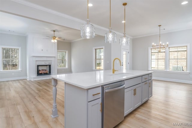 kitchen featuring an island with sink, open floor plan, dishwasher, and light countertops