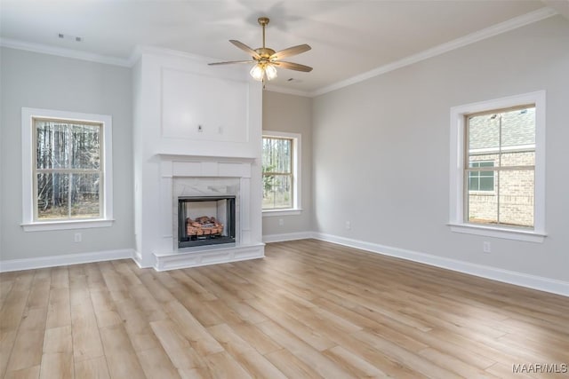 unfurnished living room featuring light wood-type flooring, a fireplace, and crown molding