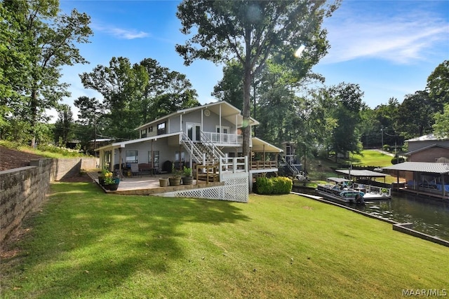 back of house with a lawn, a water view, and a patio