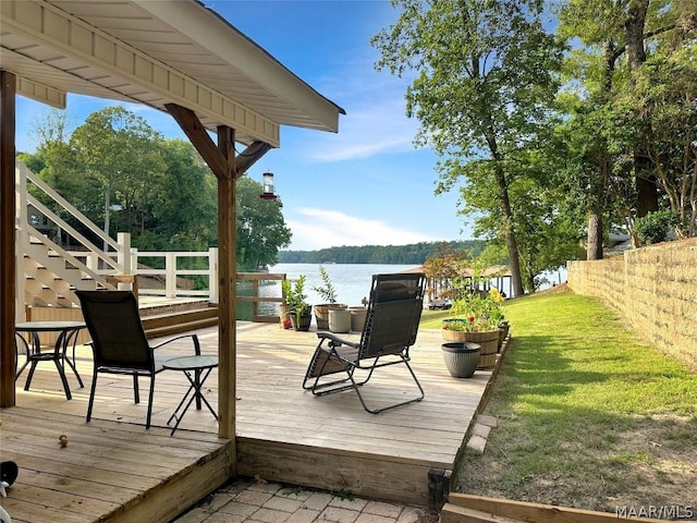 wooden terrace featuring a yard and a water view