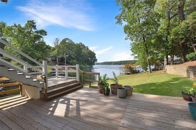 wooden deck featuring a water view and a lawn