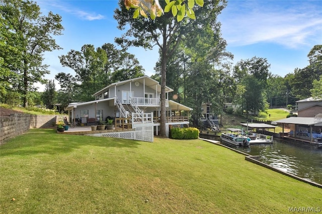 back of house featuring a lawn and a water view