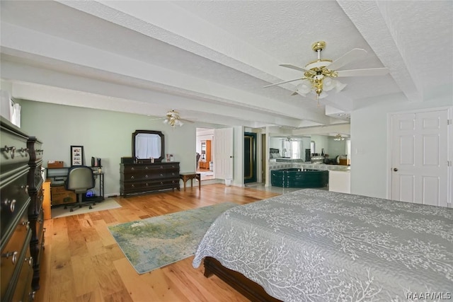 bedroom featuring beamed ceiling, ceiling fan, a textured ceiling, and light hardwood / wood-style flooring