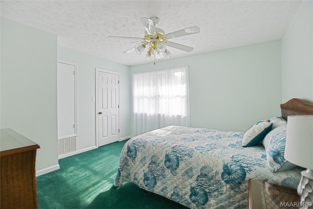 bedroom with ceiling fan, dark carpet, and a textured ceiling