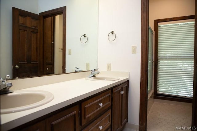 bathroom featuring an enclosed shower, a sink, and double vanity