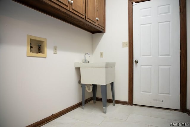 laundry area featuring hookup for a washing machine, cabinet space, and baseboards