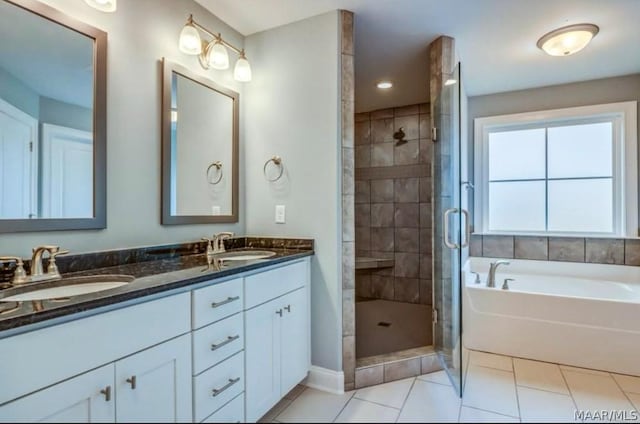bathroom featuring a shower stall, a sink, double vanity, tile patterned floors, and a garden tub