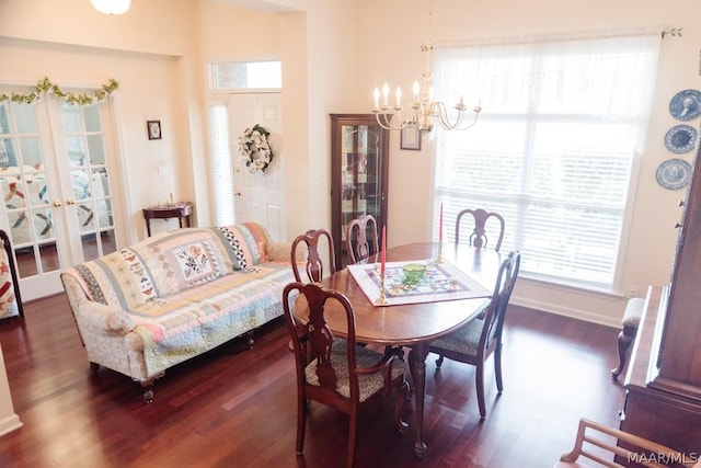 dining area featuring french doors, dark wood-type flooring, and an inviting chandelier