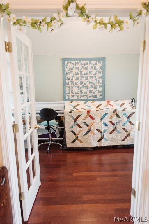 bedroom featuring french doors and dark wood-type flooring