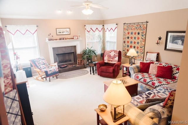 living room featuring vaulted ceiling, ceiling fan, carpet, and a fireplace