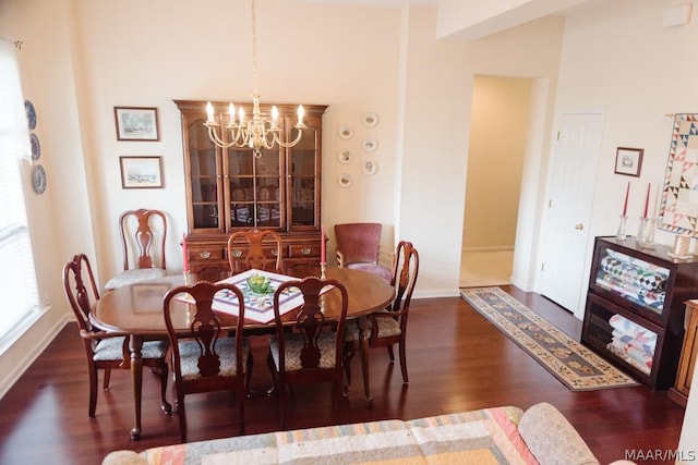 dining space featuring dark hardwood / wood-style flooring and a chandelier