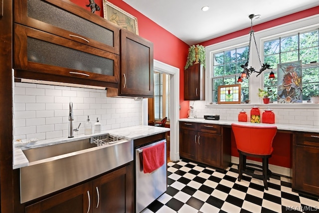 kitchen featuring backsplash, dishwasher, sink, and decorative light fixtures