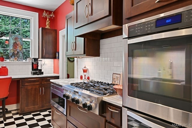 kitchen featuring decorative backsplash, dark brown cabinetry, built in microwave, cooktop, and stainless steel double oven