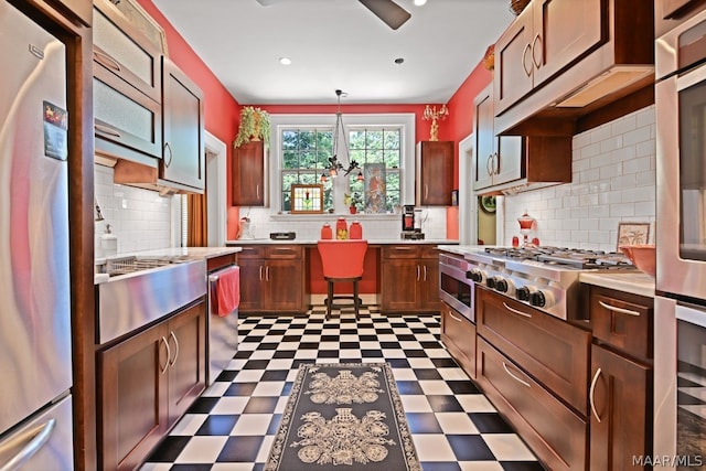 kitchen with backsplash, decorative light fixtures, and stainless steel appliances