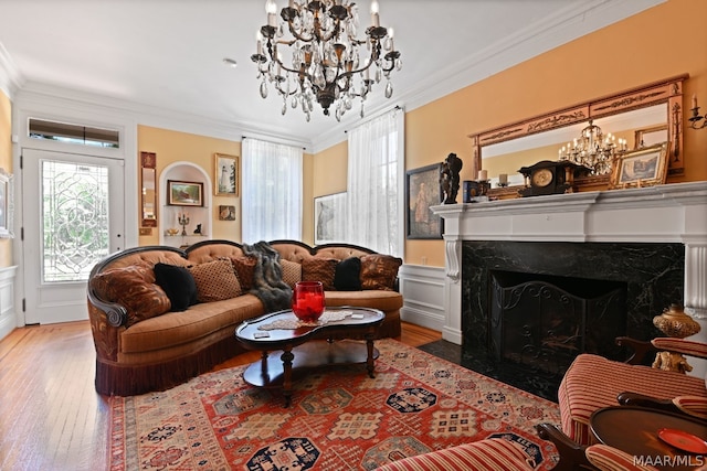 living room featuring a high end fireplace, hardwood / wood-style floors, and ornamental molding