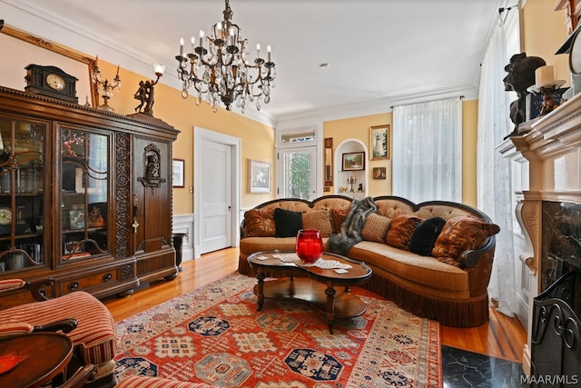 living room with wood-type flooring, a notable chandelier, and ornamental molding