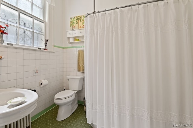 bathroom with tile patterned flooring, toilet, tile walls, and sink